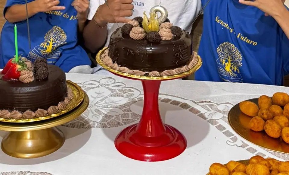 Mesa de aniversário com dois bolos de chocolate e salgadinhos